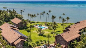 A resort with multiple buildings, a swimming pool, and a view of the ocean.