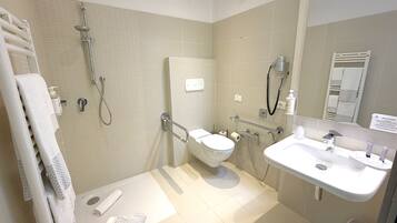 Une salle de bain moderne équipée d’une douche, de toilettes et d’un lavabo.