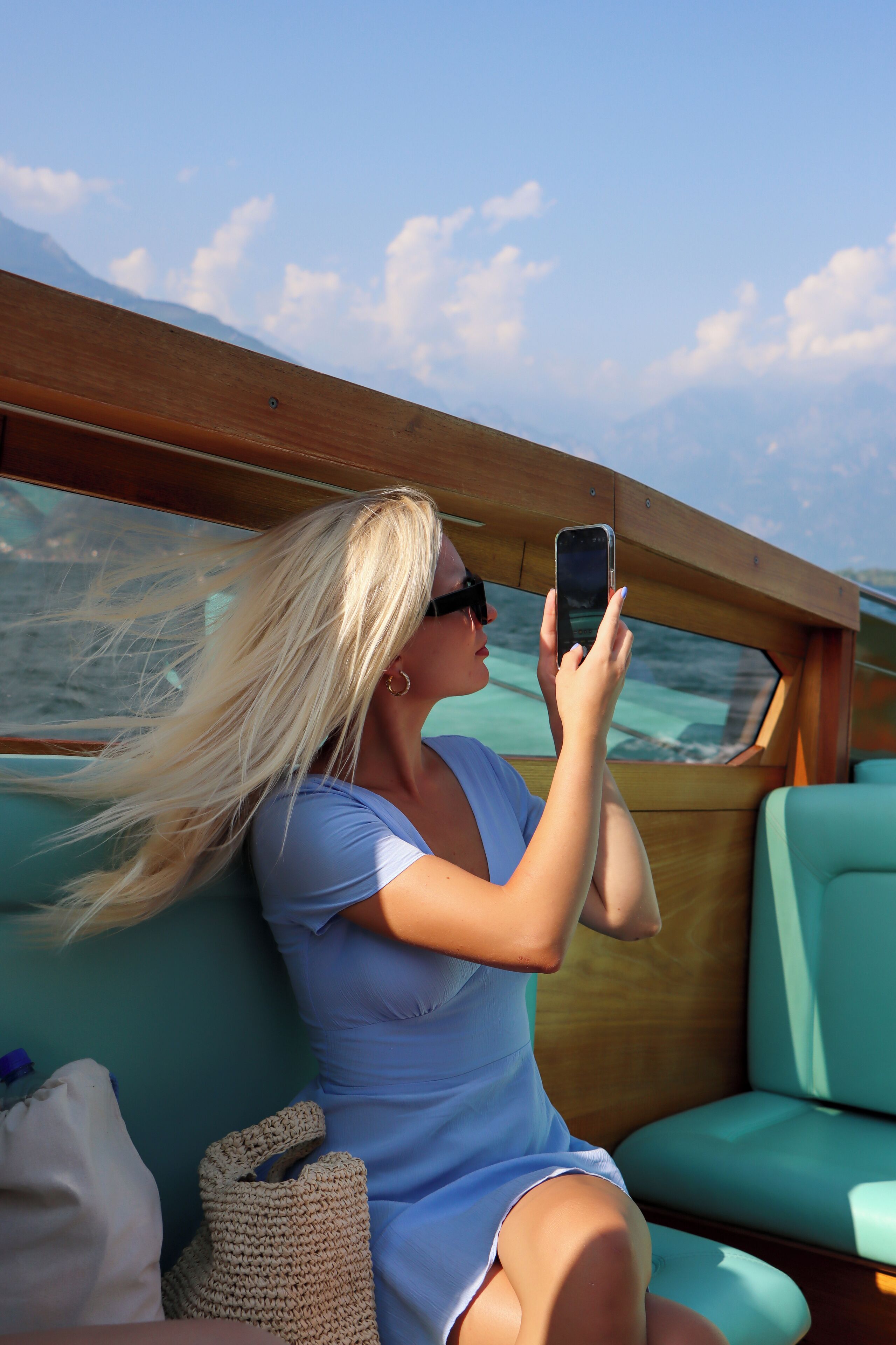 A person seated on a boat with a view of the water and sky.