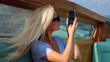 A person seated on a boat with a view of the water and sky.