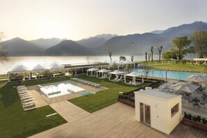 Un resort con piscina, sillas de descanso y vistas a las montañas.