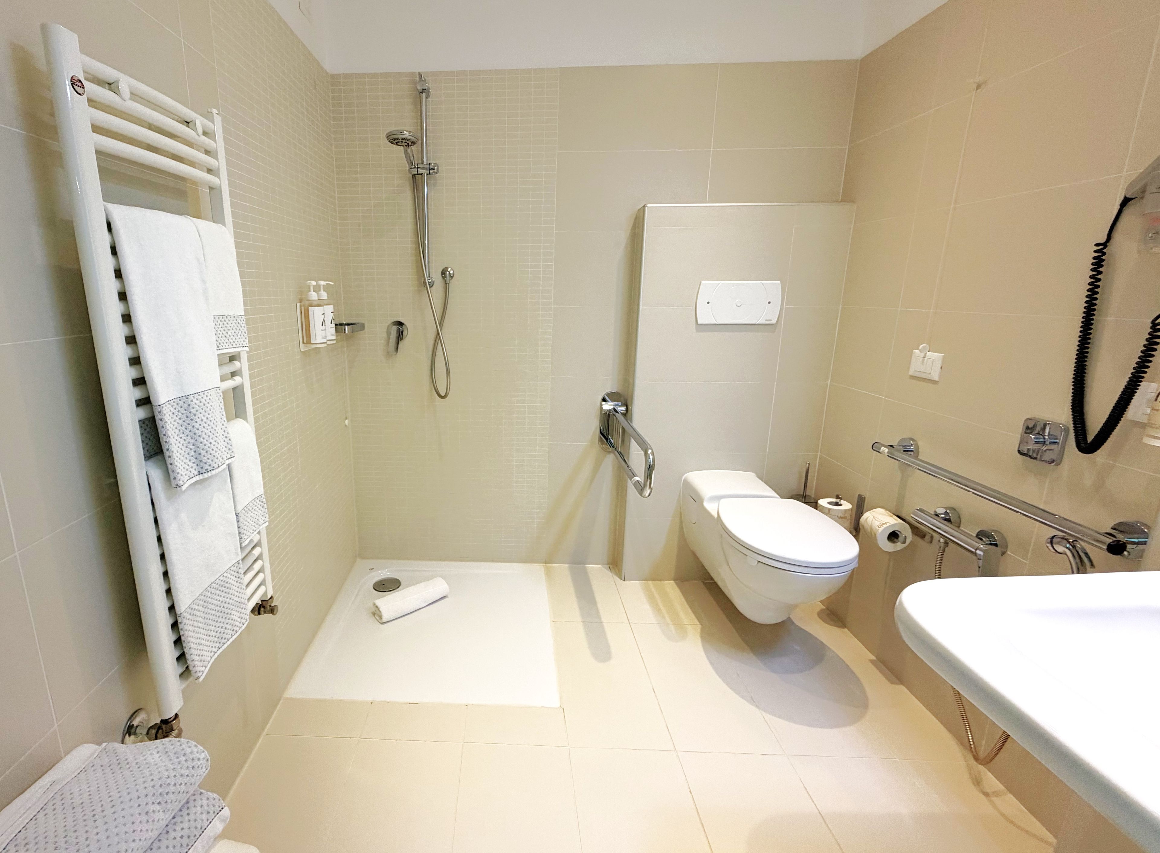 Un bagno moderno con doccia, WC e lavandino.