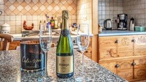 Una cocina con una botella de Visiege cava, dos copas y un recipiente de Cedarwood.