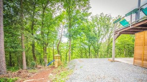 A forested area with a playground structure and a gravel path.