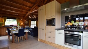 A modern kitchen with wooden cabinets, a built-in microwave, a stove, and a large window with fruit artwork.