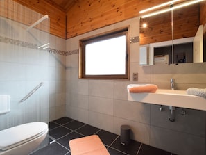 A modern bathroom with a wooden ceiling, a large window, a white sink, and a toilet. - Renovated Chalet Near Durbuy (Durbuy)