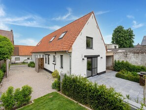 A white house with a red-tiled roof, a small garden, and a paved driveway. - Spacious Family Holiday Home (Mont-de-l'Enclus)