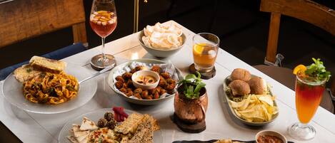 A dining table with various dishes, including pasta, bread, and a drink.