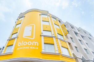 Un edificio con fachada amarilla y un letrero que dice 'bloom HERITAGE WALK'.