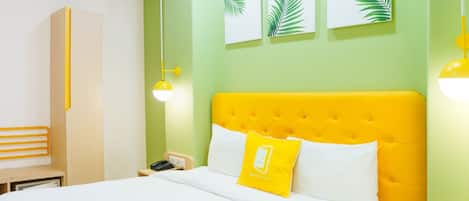 A hotel room with a large bed, a nightstand, a desk, and a wardrobe.