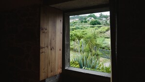 A window with a view of a garden and houses in the distance. - One of two private and intimate casitas. Surrounded by nature. (Moraña)