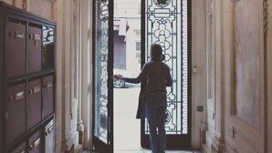 A corridor with a decorative door, a metal cabinet, and a patterned floor.