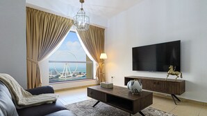 A modern living room with a sofa, coffee table, and TV. A large window offers a view of a Ferris wheel and a bridge. - Marco Polo - Full Sea & Dubai Eye View | 2 BR | Near JBR Beach (Dubai)