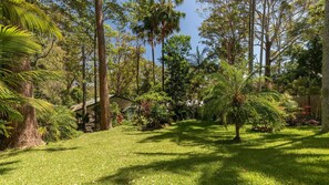 Stroll through the serene garden, surrounded by lush trees and tropical plants, and relax in the shade of a charming gazebo.