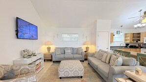 A living room with a sofa set, ottoman, and a flat-screen TV. - 3BR Beachfront North Captiva Home with Gulf Views (North Captiva)