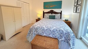 A bedroom with a bed, two bedside tables, a ceiling fan, a window with curtains, and a wardrobe. - 3BR Beachfront North Captiva Home with Gulf Views (North Captiva)