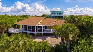A coastal house with a large balcony, a separate tower-like structure, and lush greenery surrounding it. - 3BR Beachfront North Captiva Home with Gulf Views (North Captiva)