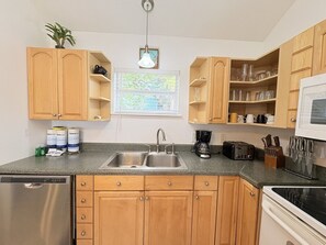 A kitchen with wooden cabinets, a double sink, a microwave, and a toaster.