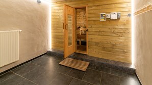 Un couloir avec une porte en bois donnant sur un sauna, un radiateur et un chauffage fixé au mur.