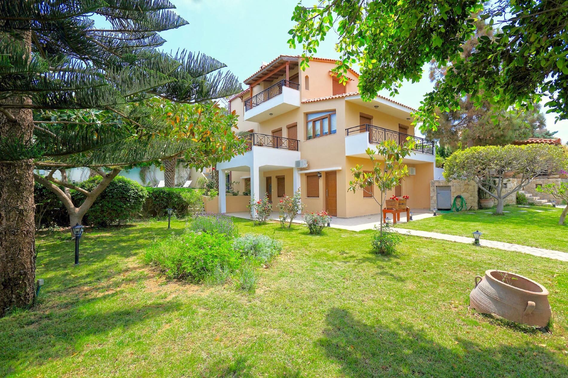Um edifício residencial de dois andares com um jardim na frente.