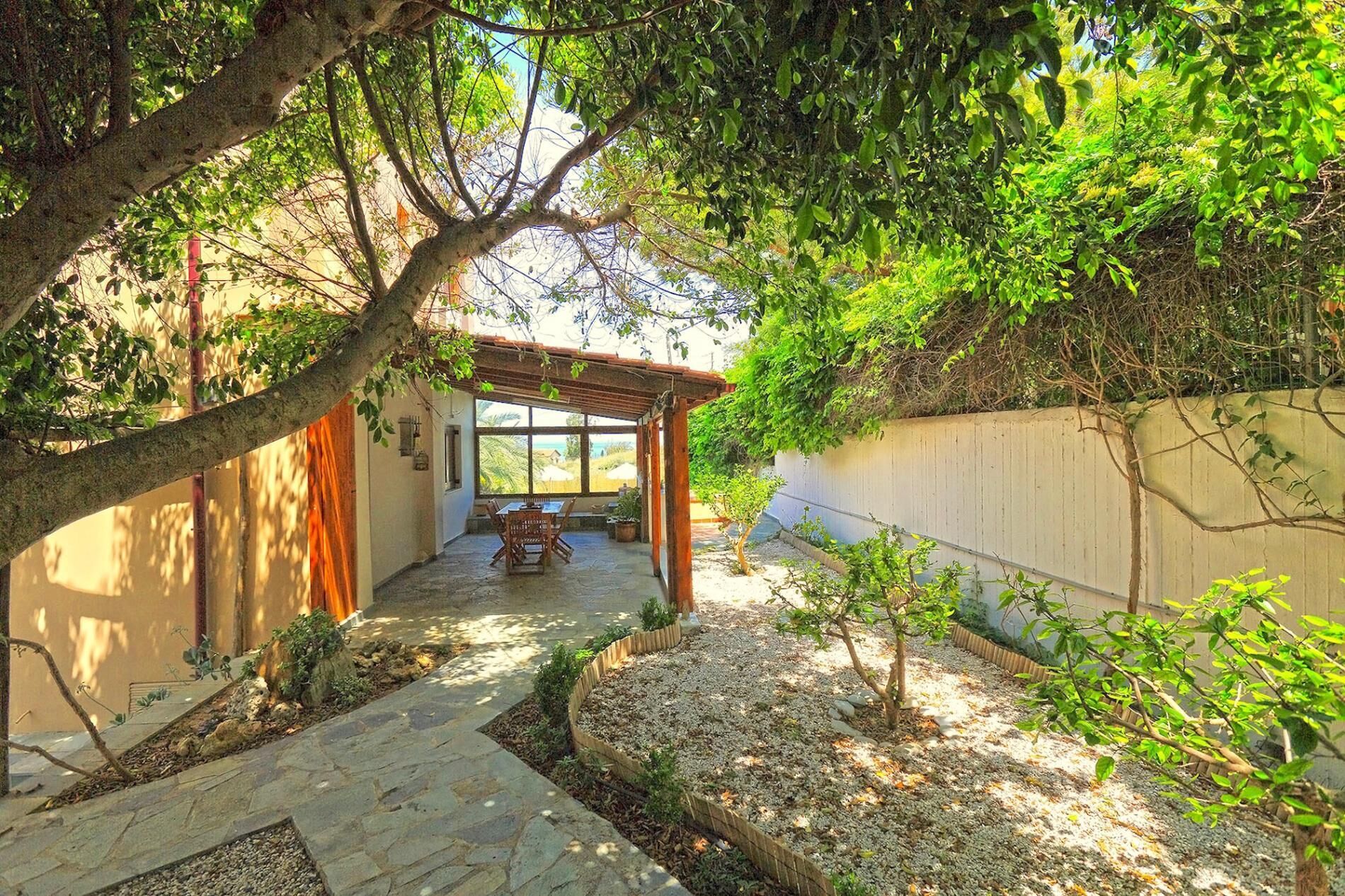 A covered patio area with a stone pathway leading to a seating area.