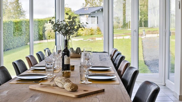 A dining table set for six with a loaf of bread, wine glasses, and a bottle of wine. - Pleasant Holiday Home With Recreation Room (Bouillon)