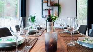 A dining table set with wine glasses, plates, and a candle centerpiece. - Holiday Home in Biron With Barrel Sauna (Erezee)