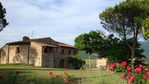 A rustic stone building with a tiled roof, surrounded by a well-maintained lawn and flowering plants. - Country house with great views, pool, garden,  panoramic terraces, free wifi
 (Torri)