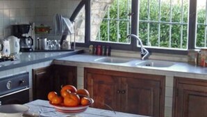 A kitchen with a large window, wooden cabinets, and a marble countertop. - Country house with great views, pool, garden,  panoramic terraces, free wifi
 (Torri)