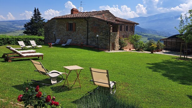 A stone house with a stone roof, surrounded by a well-maintained lawn, and a view of distant mountains. - Country house with great views, pool, garden,  panoramic terraces, free wifi
 (Torri)