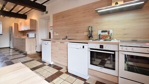 Une cuisine moderne avec des appareils électroménagers blancs, des meubles en bois et un carrelage à motifs carrés.