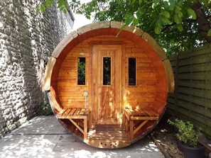 A wooden structure with a door, two windows, and a bench outside. - Luxury Holiday Home With Sauna (Hotton)