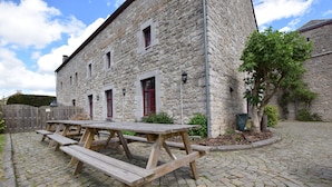 Un bâtiment en pierre avec une table de pique-nique devant.