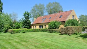 A house with a sloped roof, multiple windows, and a well-maintained lawn. - Holiday Home Het Zuidgoed With Garden (Zedelgem)