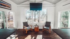 A room with two wooden chairs, a small table, and a large window with a view of trees. - Lake Murray Cottage w/ Private Dock, Fire Pit & Kayaks - Near Martin's Landing (Prosperity)