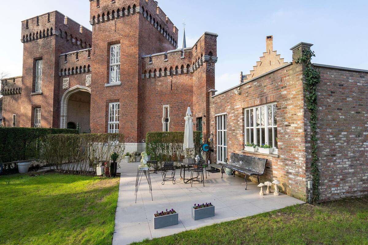 A historic brick building with a large arched entrance and a tower.