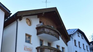 A two-story building with a wooden balcony, a sign reading "Hotel Carnot," and a circular window on the upper floor. - Retreat in Samnaun Alps (Samnaun)