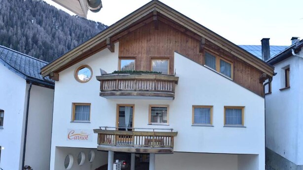 A two-story building with a wooden balcony, a sign reading "Carrot", and a mountainous backdrop. - Retreat in Samnaun Alps (Samnaun)