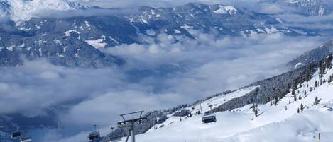 A snowy mountain landscape with ski lifts and skiers.