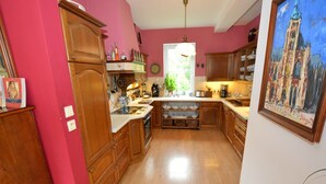 A kitchen with wooden cabinets, a central island, and a painting on the wall. - Tasteful Villa in Zernov With Private Pool (Žernov)