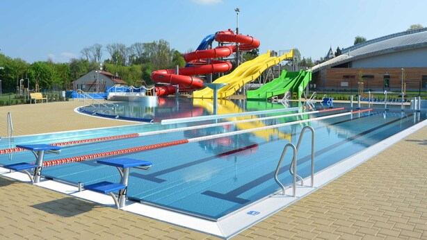 A swimming pool with lane dividers, a water slide, and a covered area with benches. - Tasteful Villa in Zernov With Private Pool (Žernov)