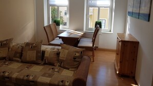 A dining area with a table and chairs, a sofa, and a radiator. - Apartment in Kamenz Sachsen Near Town Centre (Kamenz)
