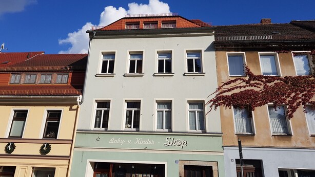A building with a sign reading "Baby-u, Kinder Shop" on the ground floor. - Apartment in Kamenz Sachsen Near Town Centre (Kamenz)