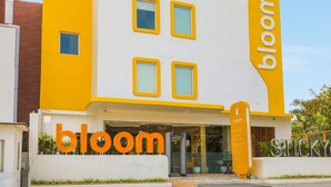 A building with a yellow and white facade, featuring the 'staybloom.com' logo at the top and 'bloom' on the side. - Bloom Hotel - Golf Course Road, Sector 43 (Gurugram)