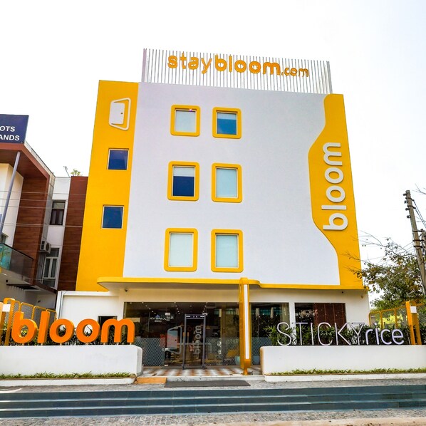 Un edificio con il cartello 'staybloom.com' nella parte superiore e 'STICKYRice' in quella inferiore.