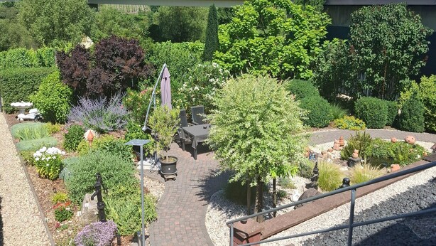 A garden with various plants and a seating area. - Garden Retreat With Pond View (Neumagen-Dhron)
