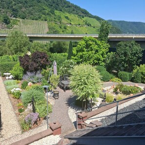 A garden with various plants and a seating area. - Ferienwohnung Moselblick (Neumagen-Dhron)