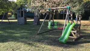 Une aire de jeux avec des balançoires et un toboggan.