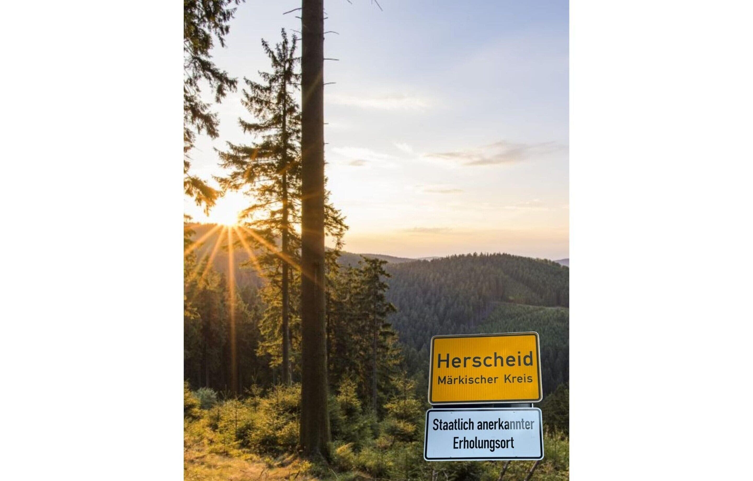 Une vue pittoresque de Herscheid, avec un paysage boisé et un lever ou un coucher de soleil.