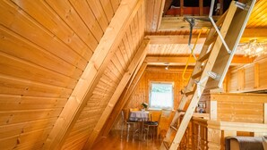 A wooden interior with a dining area, a staircase, and a window. - Gemutliches Waldversteck in Suhl (Suhl)